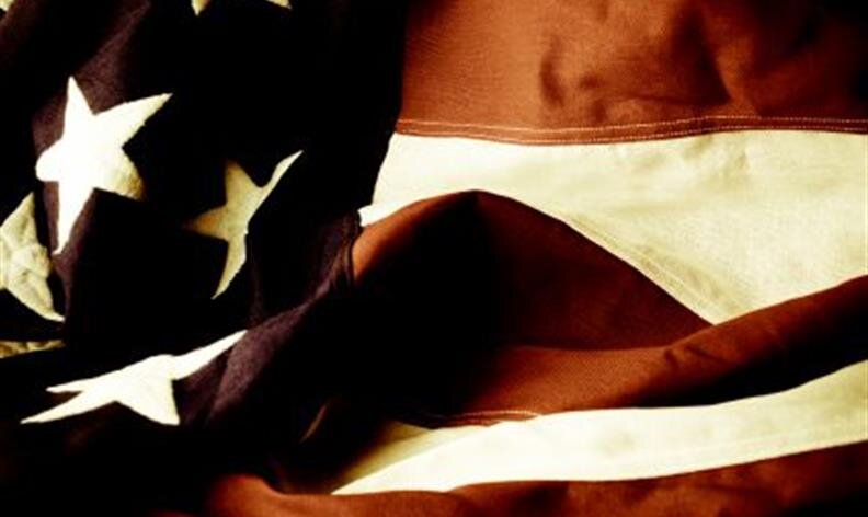 Close-up of a portion of the United States flag showing stars on blue and red and white stripes.