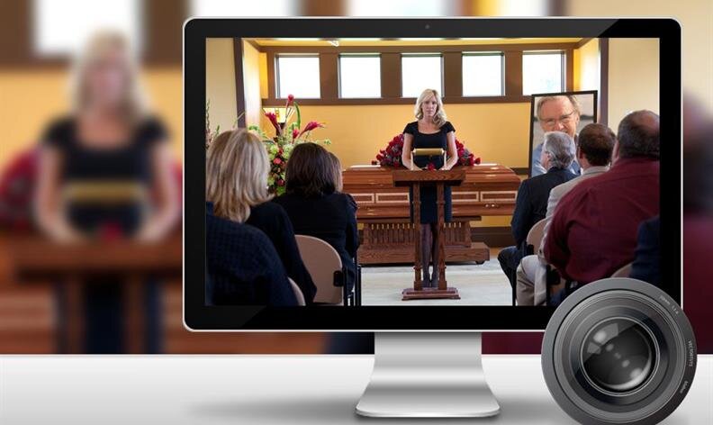 A woman delivers a eulogy at a funeral, viewed on a computer screen with attendees seated facing a casket.